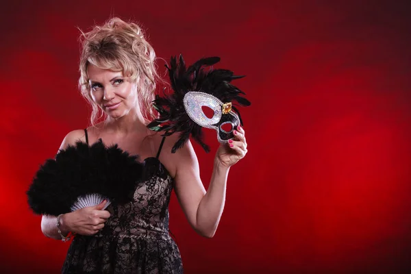 Žena držící v ruce karnevalové masky prolnutí ventilátor — Stock fotografie