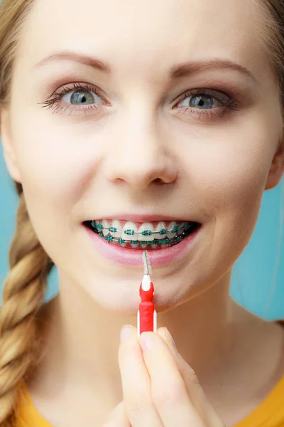 Žena s rovnátka zubů pomocí mezizubní kartáček — Stock fotografie