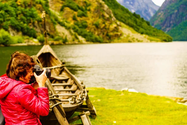 Turista con macchina fotografica vicino vecchia barca vichinga, Norvegia — Foto Stock