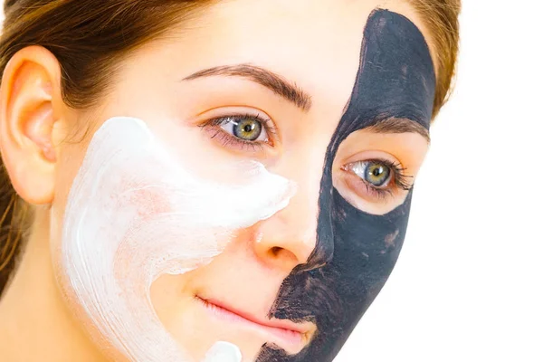 Κορίτσι μαύρη μάσκα στο μισό πρόσωπο Εφαρμόστε λευκή λάσπη — Φωτογραφία Αρχείου