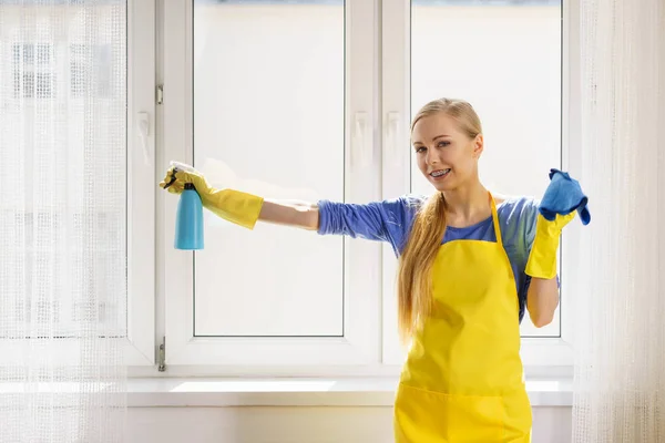 Kobieta sprzątająca okno w domu — Zdjęcie stockowe