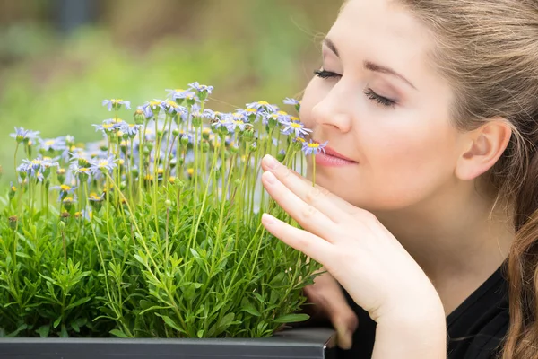 Woman smelling flowers — Stock Photo, Image