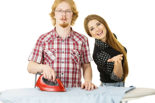 Happy woman and bored man ironing clothes — Stock Photo, Image