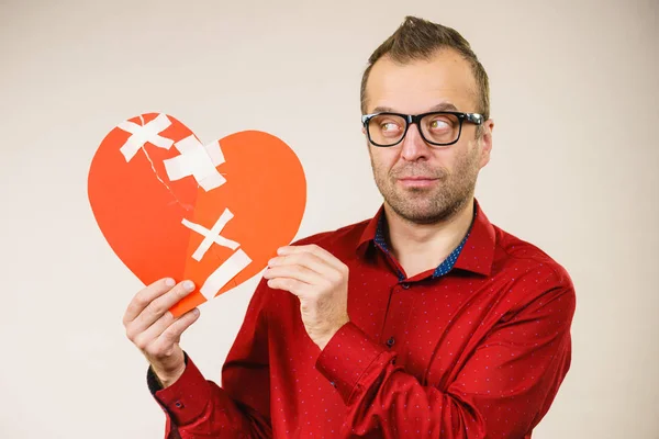 Thinking adult man holding broken heart — Stock Photo, Image