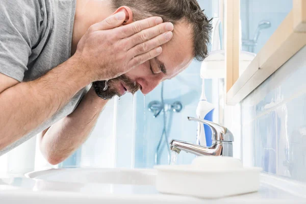 Man washing his face in bathroom — Stock Photo, Image