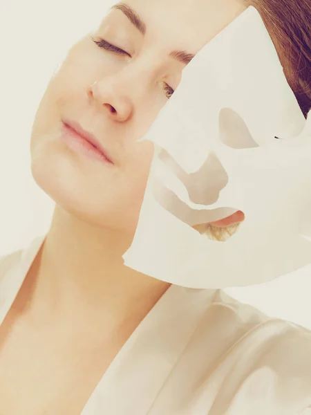 Woman removing sheet mask from face — Stock Photo, Image