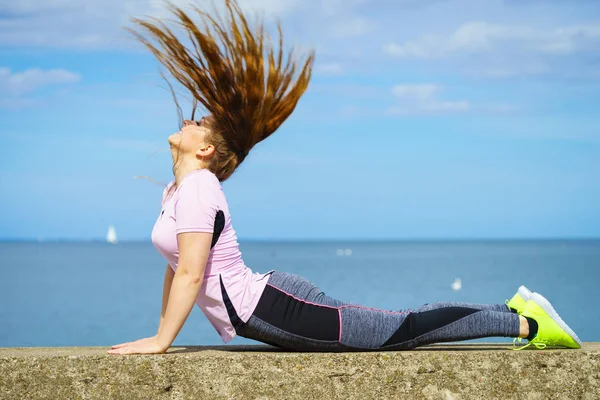 Deniz yanında yoga yaparken kadın — Stok fotoğraf