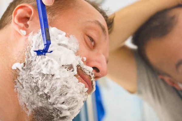 Tipo afeitándose la barba en el baño — Foto de Stock