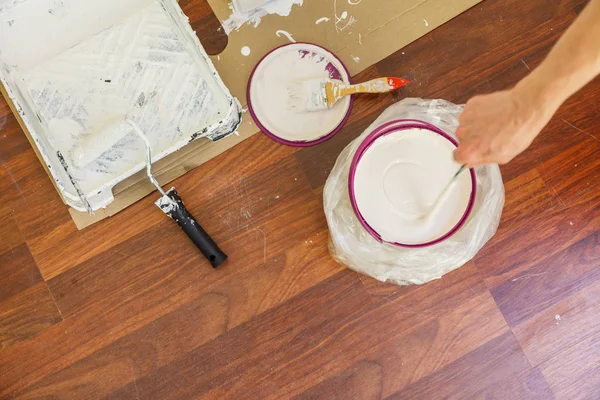 Persona mezclando pintura blanca en cubo . —  Fotos de Stock