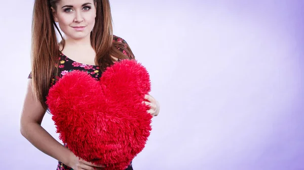 Mujer feliz sosteniendo almohada en forma de corazón — Foto de Stock