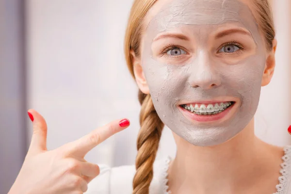 Vrouw met klei modder masker op haar gezicht — Stockfoto