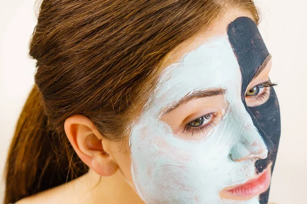 Meisje met zwart witte modder masker op gezicht — Stockfoto