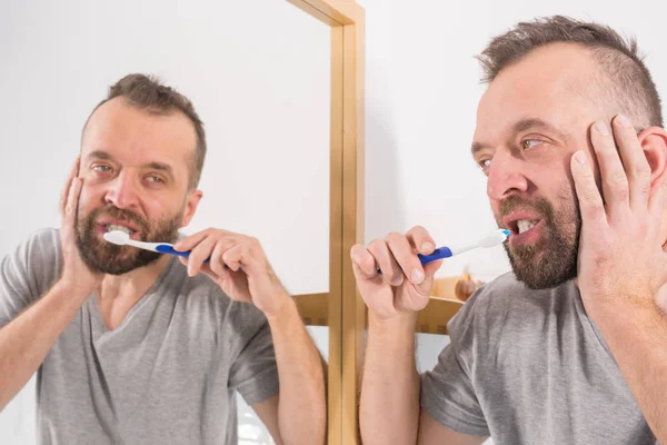 Скучный парень чистит зубы в ванной — стоковое фото