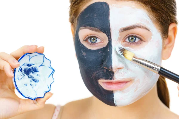 Fille masque noir sur la moitié du visage appliquer de la boue blanche — Photo