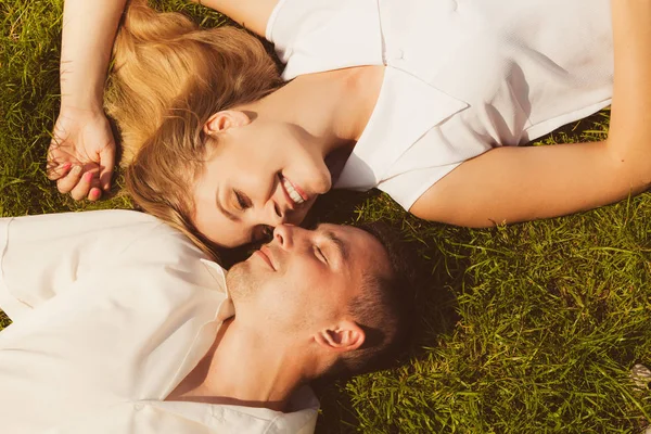 Homem e mulher deitado na grama ter data — Fotografia de Stock