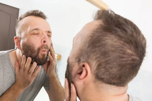 鏡であごひげを見ている男 — ストック写真