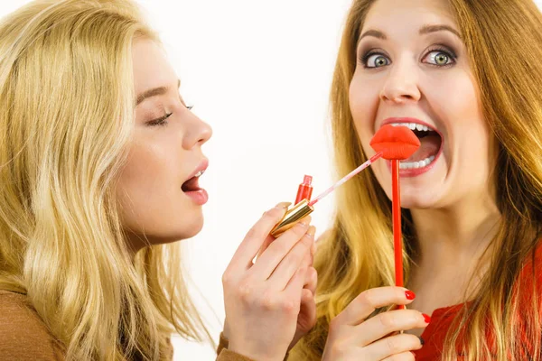 Duas mulheres e lábio produto — Fotografia de Stock