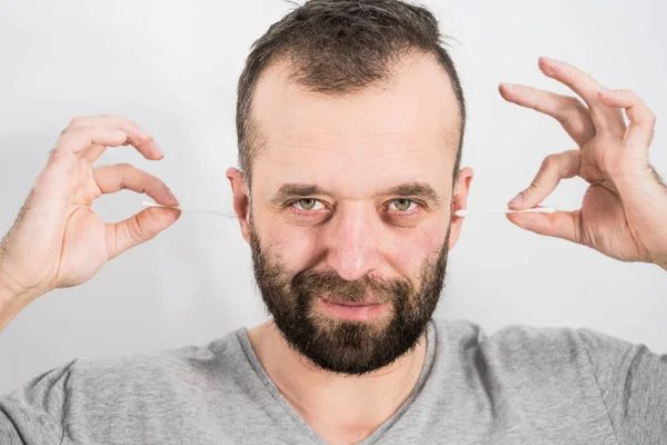 Man removing wax from ear using Q-tip