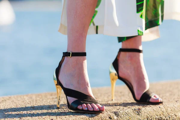 Perempuan kaki di sepatu hak tinggi di dermaga laut — Stok Foto