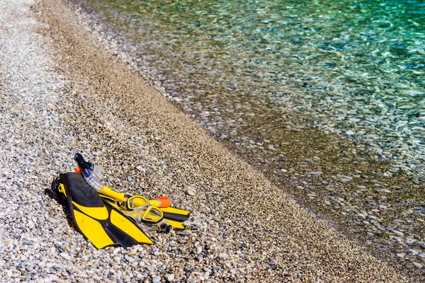 Aletas y tubo de snorkel en la orilla del mar —  Fotos de Stock