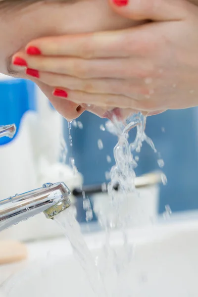 Mujer lavándose la cara en el baño. Higiene . — Foto de Stock