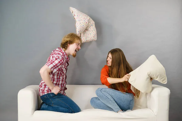 Mann und Frau liefern sich Kissenschlacht — Stockfoto