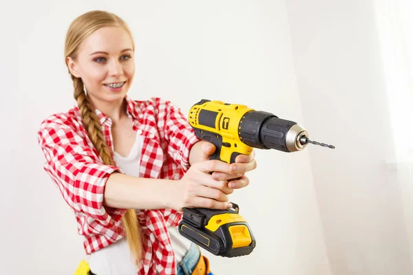 Frau mit Bohrer an Wand — Stockfoto