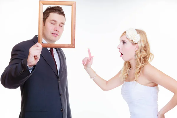 Sposo arrabbiato e sposa in possesso di cornice vuota — Foto Stock