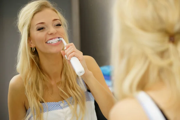 Mujer usando cepillo de dientes eléctrico —  Fotos de Stock