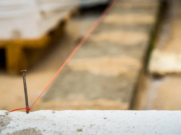 Cadena utilizada como nivel en la construcción de la pared . —  Fotos de Stock