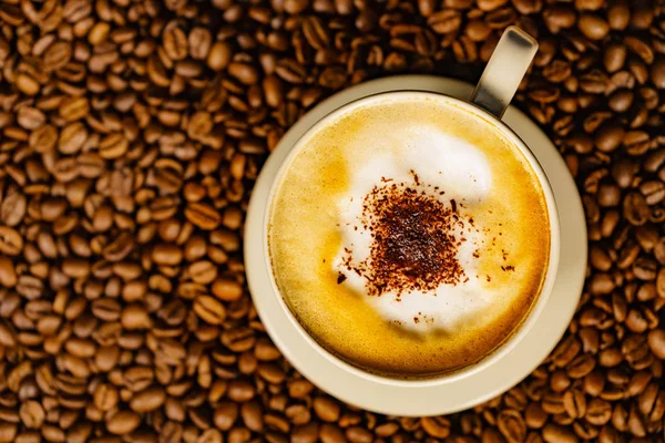 Cappuccino-kop op geroosterde koffiebonen. — Stockfoto