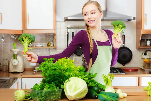 Femme dans la cuisine avec des légumes verts brocoli à la main — Photo