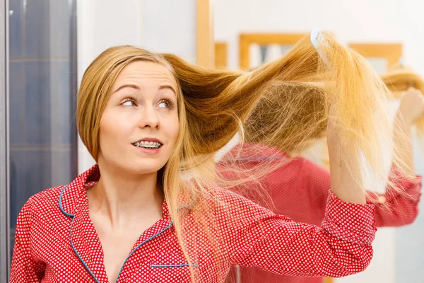 Frau kämmt ihre langen Haare im Badezimmer — Stockfoto