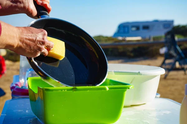 Kvinna tvätta rätter i skål, capming utomhus — Stockfoto