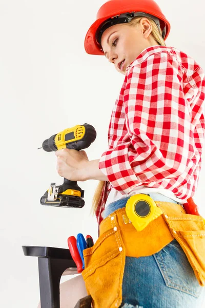 Woman using drill on ladder — Stock Photo, Image