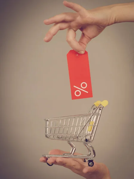 Mão com carrinho de compras e etiqueta de venda . — Fotografia de Stock