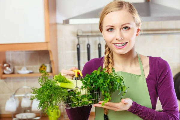 Mulher na cozinha com legumes segurando cesta de compras — Fotografia de Stock