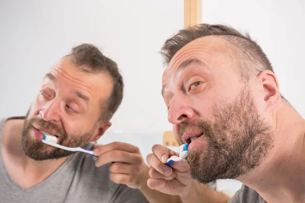 浴室で彼の歯を磨く男 — ストック写真