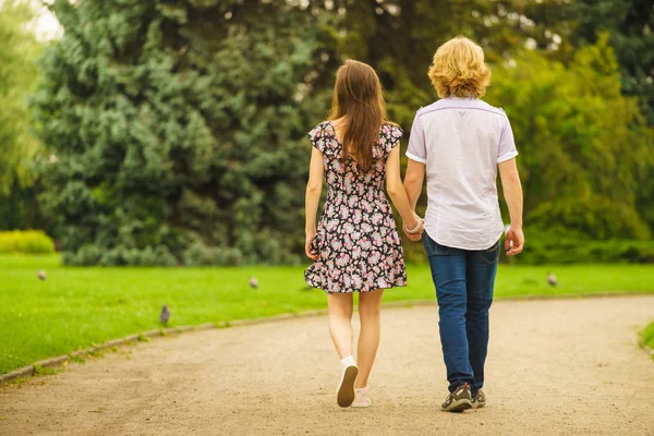 Pareja caminando tomados de la mano en el parque — Foto de Stock