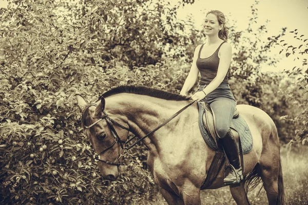 Giovane donna seduta su un cavallo — Foto Stock