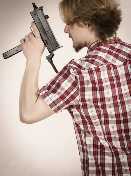Man standing backwards holding gun — Stock Photo, Image