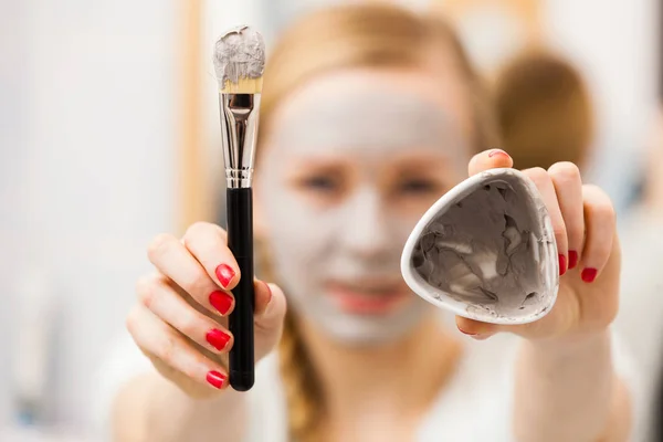 Woman applying with brush clay mud mask to her face — Stock Photo, Image