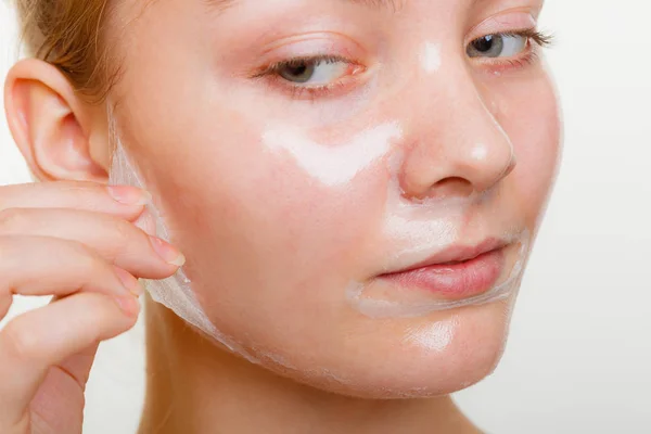 Kvinna att ta bort facial peel off mask. — Stockfoto