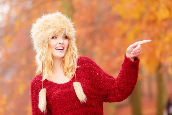 Mujer bastante sonriente en piel sombrero de invierno señalando . —  Fotos de Stock