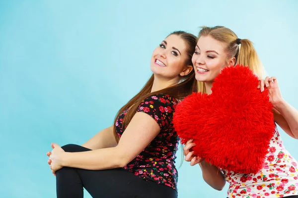 Boldog két nő, aki szív alakú párna — Stock Fotó