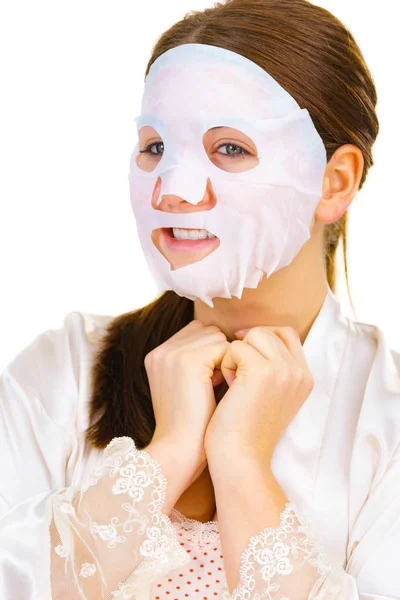 Mujer aplicando máscara de hoja en la cara — Foto de Stock