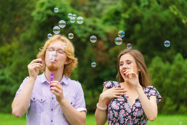Pareja soplando burbujas de jabón, divirtiéndose — Foto de Stock