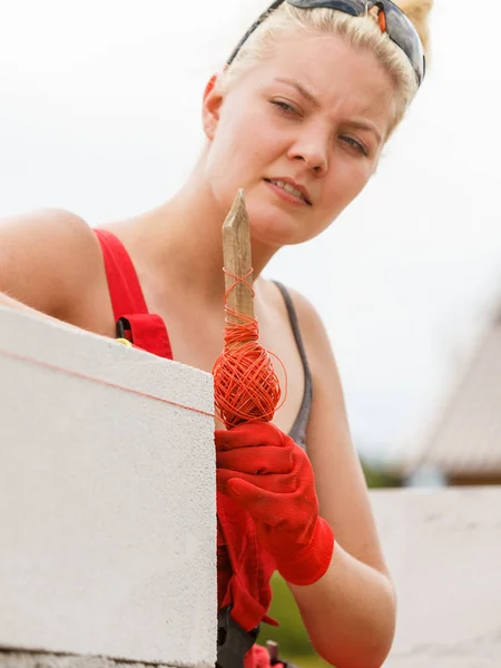 Frau nivelliert Ziegelsteine auf Baustelle — Stockfoto