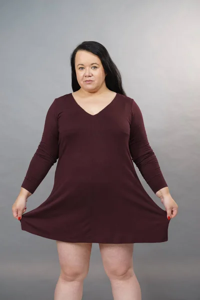 Vrouw toont grootte van bruin top tuniek — Stockfoto