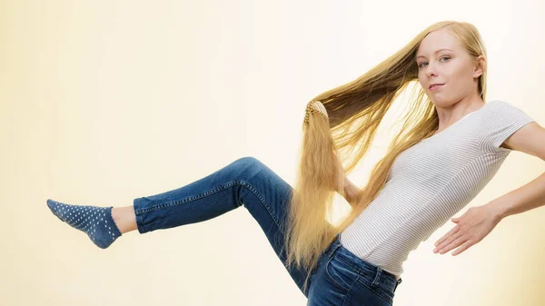 Chica rubia cepillándose el pelo largo — Foto de Stock